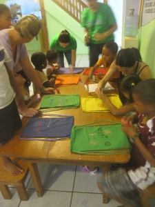 The children help decorate bags for distributing supplies to families in need