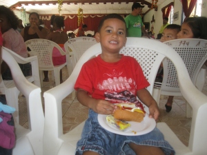 A local boy enjoying his hot dog